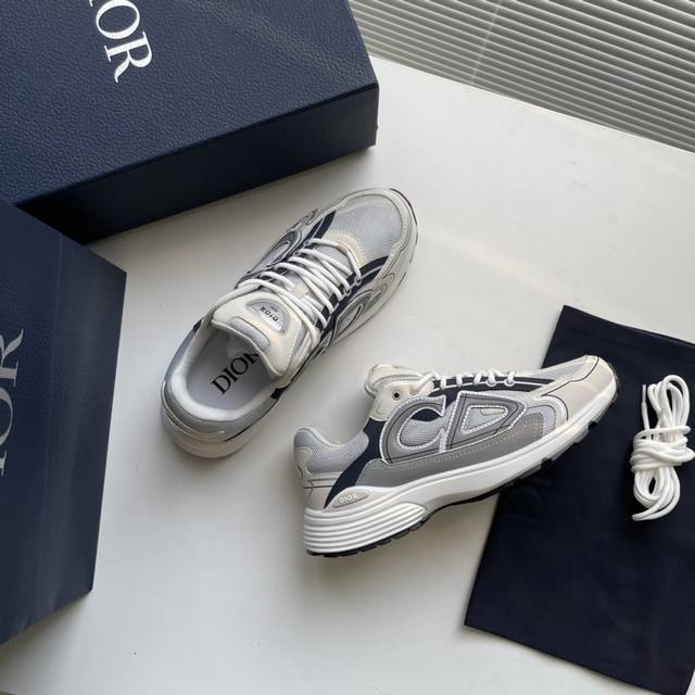D家新款 B30 低帮运动鞋 采用灰色网眼织物和白色科技面料精心制作，饰以反光“Cd30”图形标志，鞋跟和鞋舌饰以“Dio～B30”和“Cd30”标志。格外轻盈