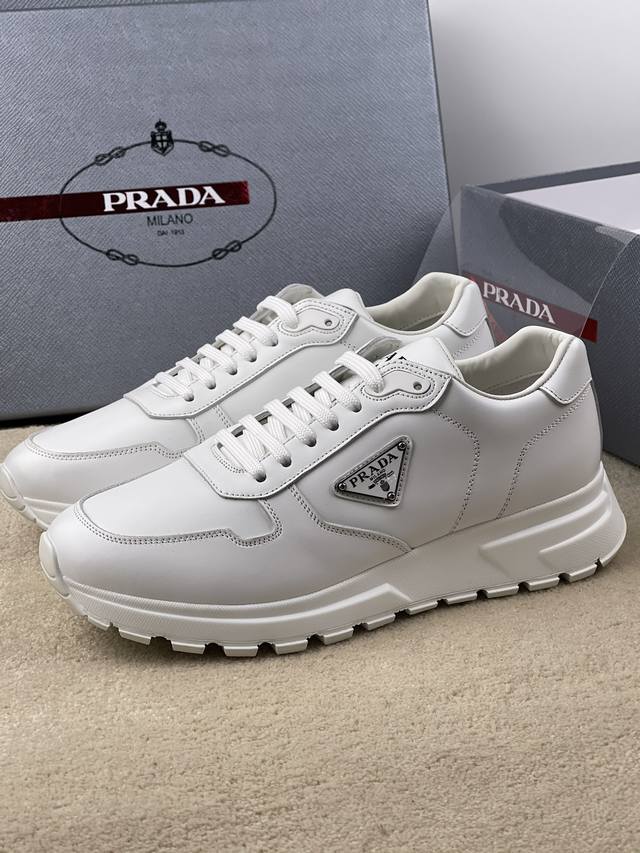Prada最新款更新 Prax 01 运动鞋融优雅的创意设计以及prada系列典型的材质于一身。鞋身采用进口纳帕牛皮面 柔软舒适 蕴含新颖运动格调的三角形徽标点