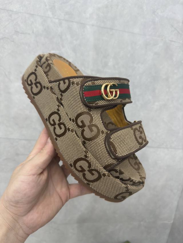 女士 Gg 厚底系带拖鞋 Gucci 女士签名鞋凸显引人注目的主题。通体提花设计带有几何 Gg 图案，饰有创始人姓名首字母。这款厚底凉鞋采用米色和乌木色帆布材质